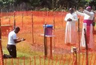 Bức hình một linh mục Congo nhiễm Ebola quỳ gối xin Giám Mục đứng từ xa ban phép lành