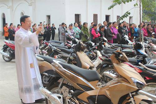 Cha Giuse Nguyễn Trọng Dưỡng rẩy nước thánh lên các xe máy tại nhà thờ Vĩnh Quang vào ngày mồng 3 Tết. Ảnh: Giuse Nguyễn